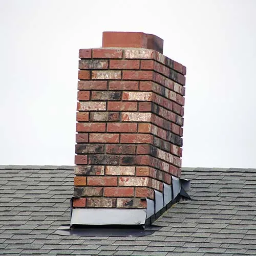 Brick Chimney. A red brick masonry chimney on a residential home.