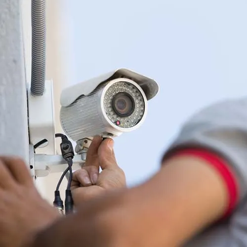 Young man setting security camera system.
